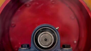 Close up of rotating metal mechanism, concept of heavy industry and construction. Media. Side view of moving round shaped trommel of red color. video