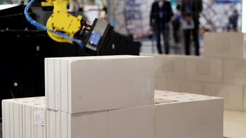 Automatic bricklayer robot working for building a wall. Media. Close up of automated machine presented at the robotic exhibition of technologies in construction industry. video