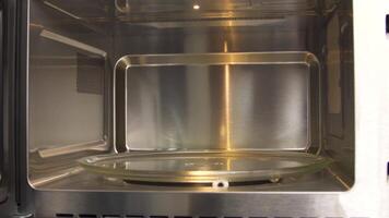 vicino su di dimostrando il spazio dentro il vuoto microonde forno. domestico utensili. nuovo modello di un' microonde, concetto di tecnologie per casa uso. video