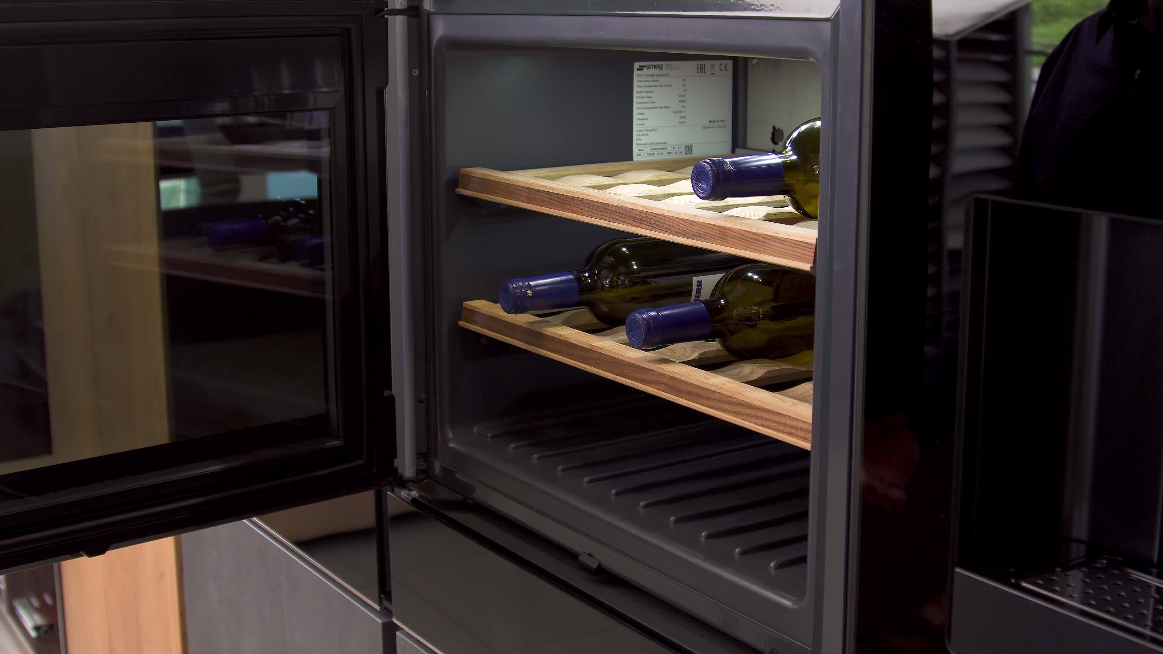 Wine bottles cooling on refrigerator wooden shelves. Household utensils