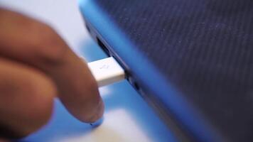 Close up of hand putting USB cable into external hard disk isolated on white background. Media. USB cable for transfering data from others device to computer, accessories for work, social network. video