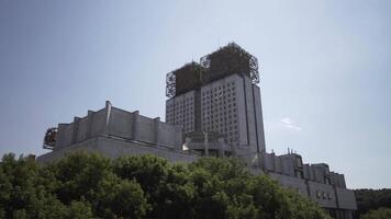 Mosca, Russia, estate città e il edificio di il presidio di il russo accademia di scienze. azione. bellissimo verde alberi e un' edificio con insolito struttura su il tetto. video