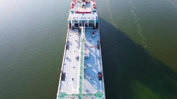 largo carga Embarcacion en verde río antecedentes. imágenes. parte superior ver de carga Embarcacion flotante en verde río con pequeño barcos agua carga transporte flotante en río en verano video