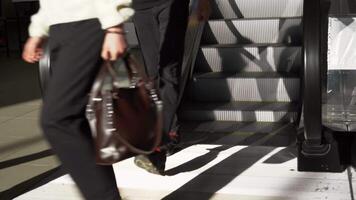 personas utilizando escalera mecánica a subterraneo estación. medios de comunicación. muchos hombres y mujer con pantalones Moviente abajo el escalera mecánica. video