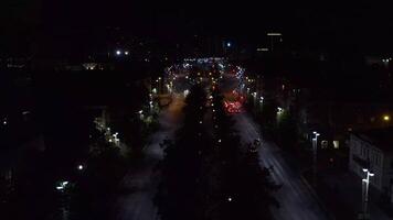 Top view of dark city at night with glowing lanterns. Stock footage. Beautiful view of highway with cars and lanterns. Night road in the center of modern city with lanterns video