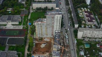 parte superior ver de construcción de de muchos pisos edificio en ciudad. valores imágenes. construcción de de muchos pisos edificio en ciudad centrar en verano día. panorama de moderno ciudad con construcción de Alto video