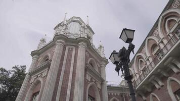 se av de palats, historisk och arkitektonisk museum, tsaritsyno i Moskva, Ryssland. handling. botten se av en vit skön byggnad nära svart lykta i dimmig väder. video