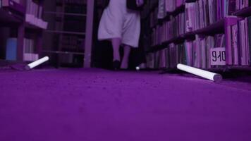 mulheres estão misteriosamente caminhando dentro biblioteca. estoque imagens de vídeo. segredo fraternidade dentro noite biblioteca. elegante mulheres misteriosamente reunir dentro noite biblioteca com piscando luz video