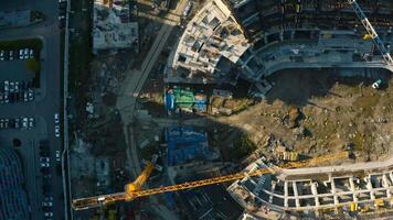 Haut vue de stade construction. Stock images. construction site avec grues et machinerie dans ville centre. construction de des sports arène dans ville sur ensoleillé été journée video