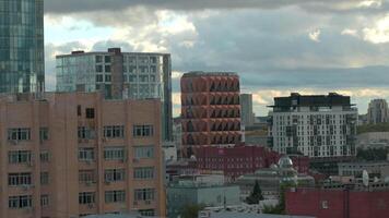 Top view of modern buildings and facades of city. Stock footage. Beautiful view of city between modern high-rise buildings. Beautiful buildings of modern city with green landscapes on background video