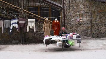 Georgië, tbilisi - september 26, 2023. bazaar met mensen in bergen. voorraad filmmateriaal. toerist bazaar met souvenirs tussen rotsachtig bergen. souvenirs zijn verkocht hoog in bergen Bij voet van kliffen video