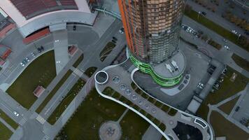 Top view of colorful glowing high-rise on summer day. Stock footage. Beautiful facade of luminous high-rise in modern city. Modern architecture of high-rise buildings with luminous facade video