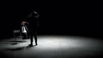 Man combs his hair in front of mirror on stage. Stock footage. Man in suit combs hair in front of mirror. Stage production with one man in suit and mirror video