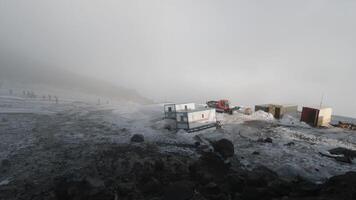 vue de le colline Haut de une géologique base avec bandes annonces et machinerie. agrafe. brumeux temps dans montagnes couvert par neige, concept de science. video