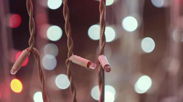 LED Christmas garlands blinking on the background of bokeh blurred lights. Concept. Close up of flashing lights of light pink color, New Year and Christmas time. video