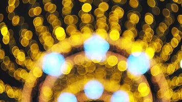 Blurred beautiful golden lights, festive Christmas and New Year background. Concept. Bokeh yellow lights of shining garland in a form of sun rays. video