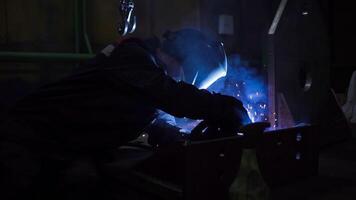 professionnel ouvrier dans masque soudures les pièces à usine. agrafe. soudeur dans salopette travaux à usine. soudage de métal les pièces dans usine video