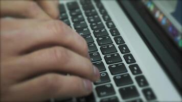 Working online on the keyboard of a laptop. Stock footage. Close up of male hands typing text on the keyboard, pressing the buttons with his fingers. video