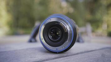 Close up of opened aperture on camera lens. Action. Camera lens, details of professional equipment for photo and video shooting on blurred background.