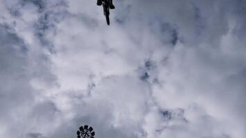 Unterseite Aussicht von ein Junge Silhouette Springen mit seine bmx Fahrrad auf Blau wolkig Himmel Hintergrund. Aktion. durchführen ein tot Schleife Trick, Konzept von extrem Sport Aktivität. video