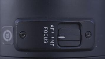 Extreme close up of camera lens details. Action. Manual MF and auto AF focus switch button on and off on the side of professional camera. video