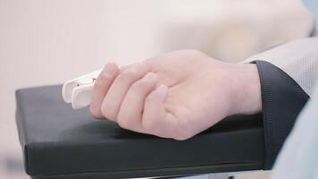 Close up of a human hand with a sensing device connected to it. Action. Sedated patient with a heart rate on a finger during surgery. video