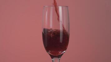 vicino su di ciliegia o Melograno succo è versato in un' bicchiere. azione. Riempimento un' trasparente bicchiere con un' delizioso succo, concetto di vitamine dieta. video