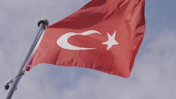 Turks vlag golvend Aan helder blauw lucht achtergrond. actie. bodem visie van een rood Turks zwaaiend in de wind. video