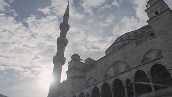 Bottom view of an ancient beautiful mosque on the background of blue cloudy sky and shining sun. Action. Concept of religion and architecture. video