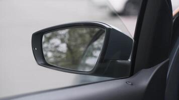 dichtbij omhoog van sluitend de auto venster. actie. visie van de auto interieur naar de kant venster en en een spiegel Aan straat asfalt achtergrond. video