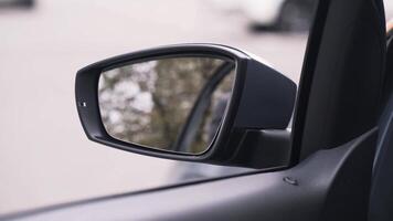 dichtbij omhoog van opening de auto venster. actie. visie van de auto interieur naar de kant venster en en een spiegel Aan straat asfalt achtergrond. video