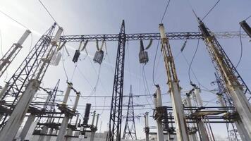 Bottom view of a power electricity lines on blue sky background. Action. High voltage electricity power line, providing cities with electricity. video