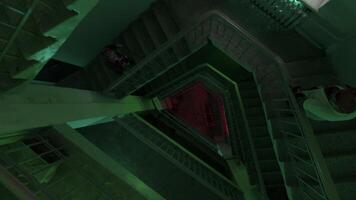 Haut vue de une rond en forme de escalier en dessous de clignotant lumières de coloré ampoules. Stock images. en volant vers le bas le long de escaliers de une multi étage bâtiment, concept de fête et musique. video