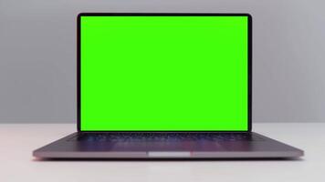 stänga upp av en ny bärbar dator dator med krom nyckel övervaka. handling. öppnad bärbar dator med grön skärm isolerat på vit vägg bakgrund. video