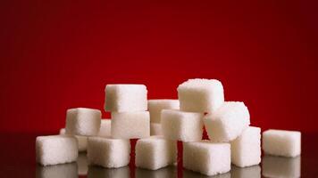 Pile of sugar cubes on isolated background. Stock footage. Pile of sugar cubes changes in number on isolated background. Sweets in large quantities are harmful to health. Sugar and sweets are 21st video