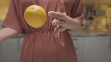 mulher jogando limão dentro mãos. Ação. fechar-se do mulher magistralmente lança limão a partir de mão para mão. mulher tocam com limão antes culinária. profissional casa cozinhando video