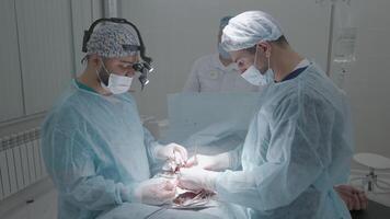 operando habitación durante operación con dos cirujanos acción. lado ver de operación debajo anestesia por dos cirujanos profesional cirujanos en proceso de operando video