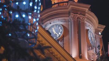 City Hall building glows beautifully in evening. Stock footage. Street lamp with garland on background of historic building. City Hall with clock tower in evening video