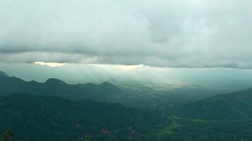 lindo Visão do montanha verde vale com nuvens e luz solar. Ação. pitoresco panorama do verde montanhas e baixo nuvens com Sol quebra através. do sol raios em horizonte dentro verde montanha video