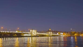 Turkey, Istanbul-December, 2020. Timelapse of luminous bridge. Action. Coast and bridge glow with bright lights with passing boats in evening. Evening harbor in lights and with many passing boats video