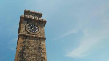 Historic clock tower with picturesque clouds and blue sky on the background. Action. Low angle view of the ancient brick tower. video