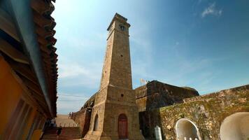 antico orologio Torre nel fortezza. azione. bellissimo soleggiato Visualizza di pietra muri e orologio Torre nel antico fortezza. antico fortezza con orologio Torre su soleggiato estate giorno video