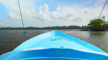 Fishing boat in the river, first person view. Action. Old boat floating along green shore and blue cloudy sky on the background. video