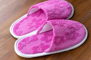 Pink Slippers Resting on Wooden Floor photo