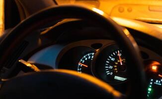 Blurred lights and dashboard view inside moving car on night highway photo