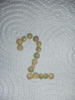 a number made out of beans on a white bed photo