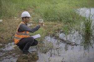 los ingenieros ambientales inspeccionan la calidad del agua, llevan el agua al laboratorio para su análisis, verifican el contenido de minerales en el agua y el suelo, verifican los contaminantes en las fuentes de agua. foto