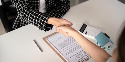 Real estate agents and customers shake hands to congratulate on signing a contract to buy a house with land and insurance, handshake and good response concept photo