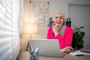 Muslim business woman hijab working about financial with business report and calculator on laptop in home office photo