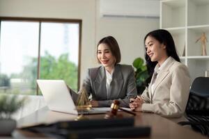 Lawyers woman and businesswoman discussing contract papers sitting at the table. Concepts of law, advice, legal service photo